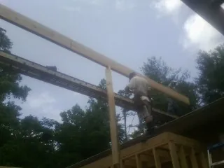 Carpenter setting a ridge beam over a new addition frame — Ice Dam Removal by Roofing Brothers in El Dorado Springs