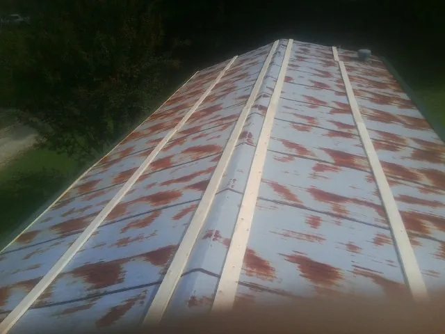 Rusted metal roof panels with new wood purlins before replacement — Storm Damage Roof Repair in El Dorado Springs by Roofing Brothers