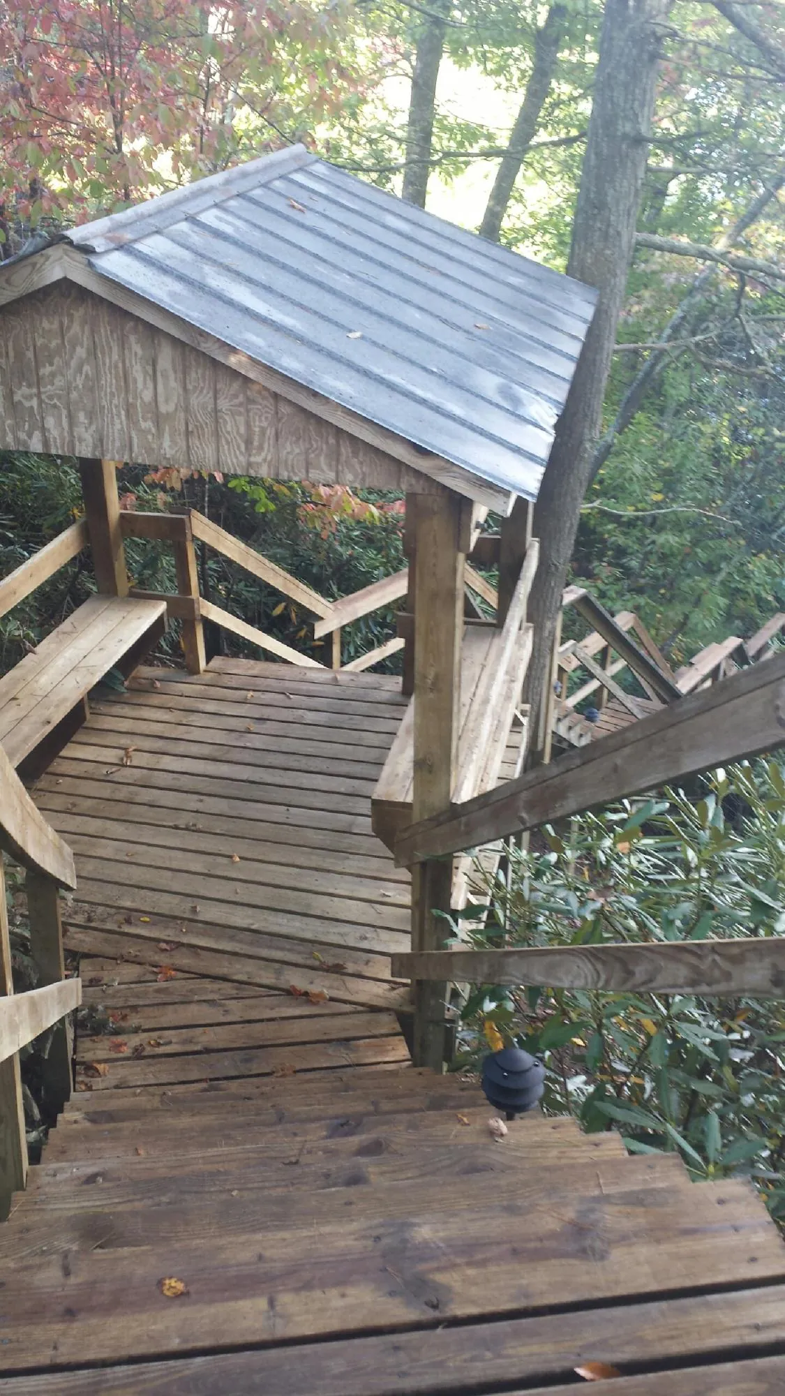 Metal roofed shelter over wooden steps on a wooded walkway — Skylight Repair & Installation work by our crew in El Dorado Springs