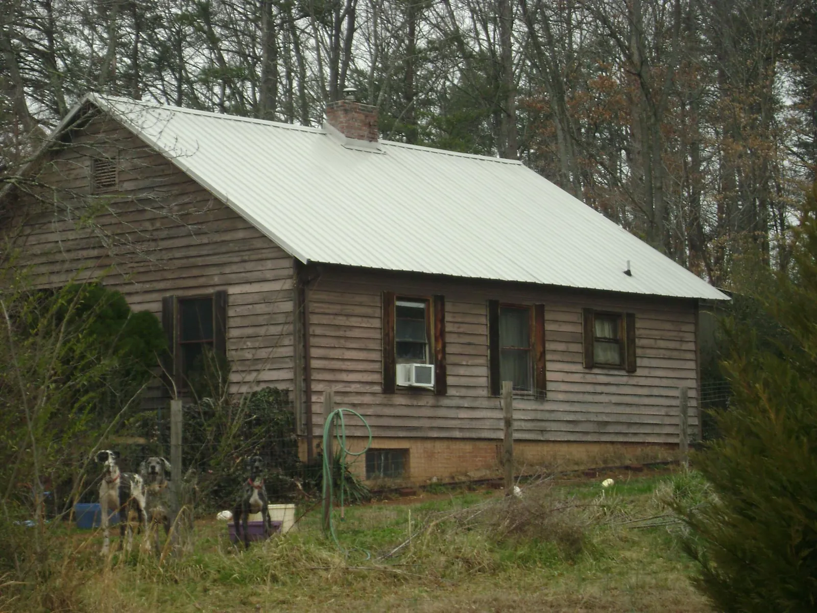 White metal roof on an old wood sided farmhouse, from a Metal Roof Installation job in El Dorado Springs